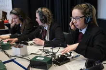 Three school students operating an amateur radio station during an ARISS contact with the International Space Station.