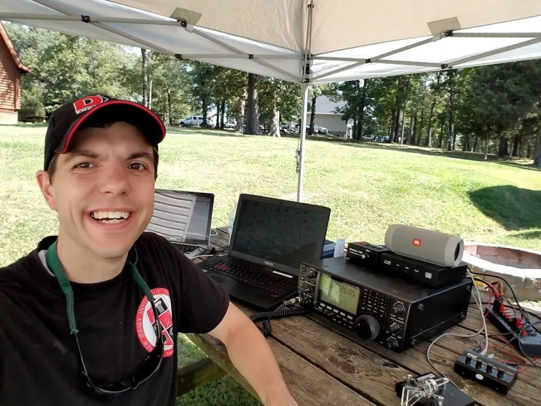 Nathaniel Frissell, principal investigator of the NASA-funded SPARC project, operating an amateur radio field station outdoors with a transceiver and laptops.
